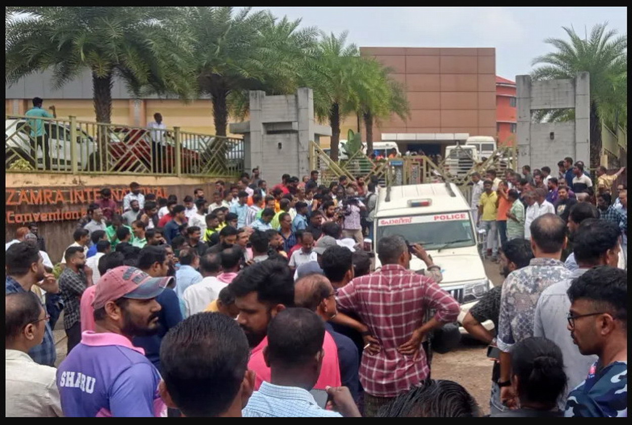 People stand outside the Zamra International Convention and Exhibition Centre where multiple blasts occurred during a religious gathering of Jehovah's Witnesses (Reuters)